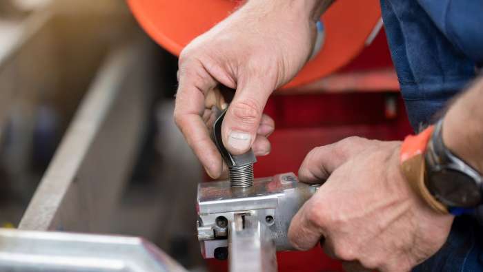 Close up of hands fixing a heavy duty machine